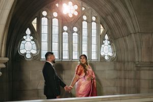Couple sharing a romantic moment in a gothic cathedral setting with ornate stained glass windows.
