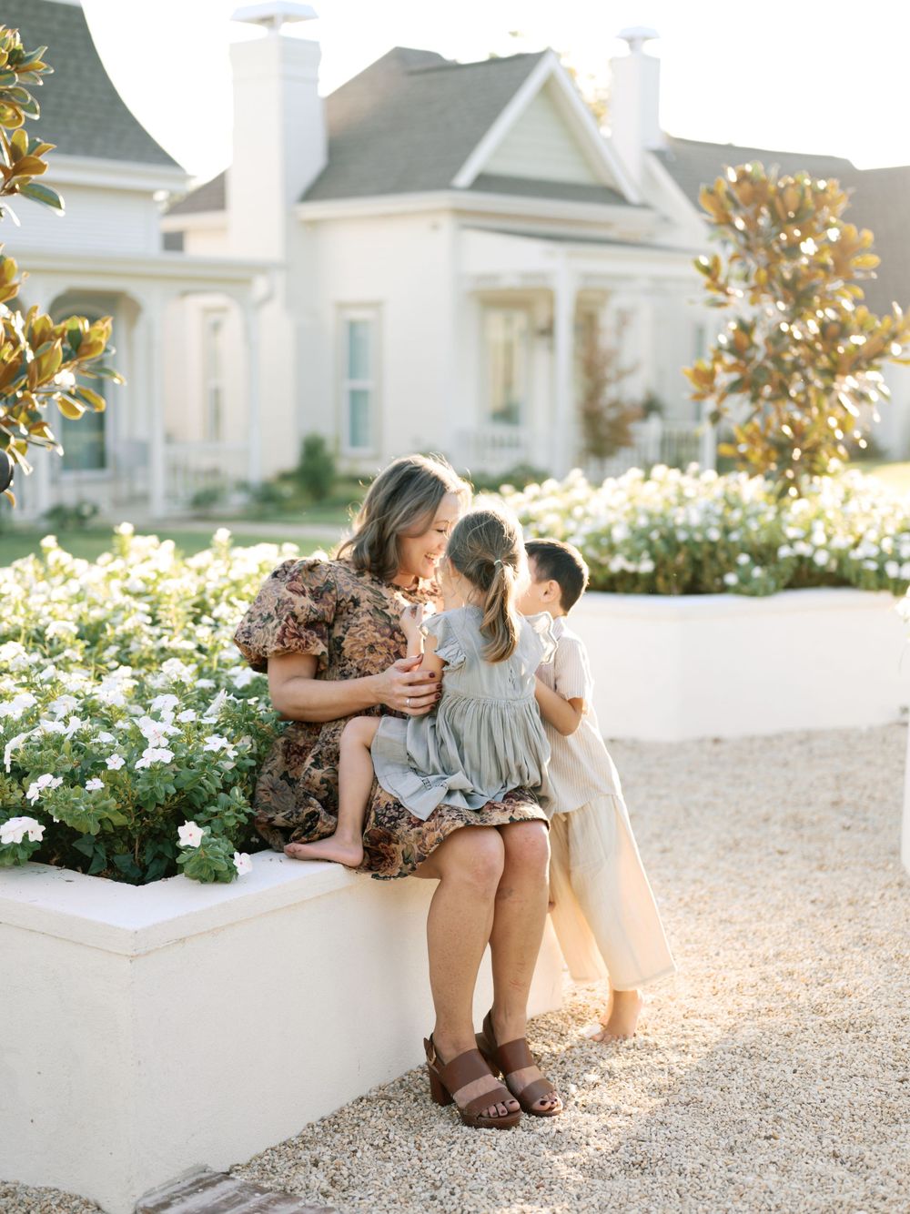 A series of candid outdoor portraits showing tender moments between family members sitting on a white ledge at sunset.