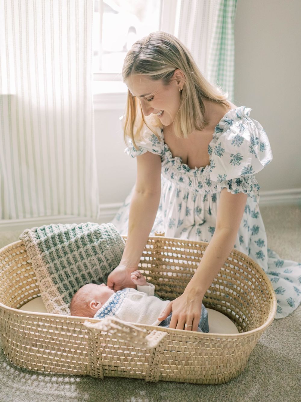 in-home newborn session of mom looking at baby in a moses basket