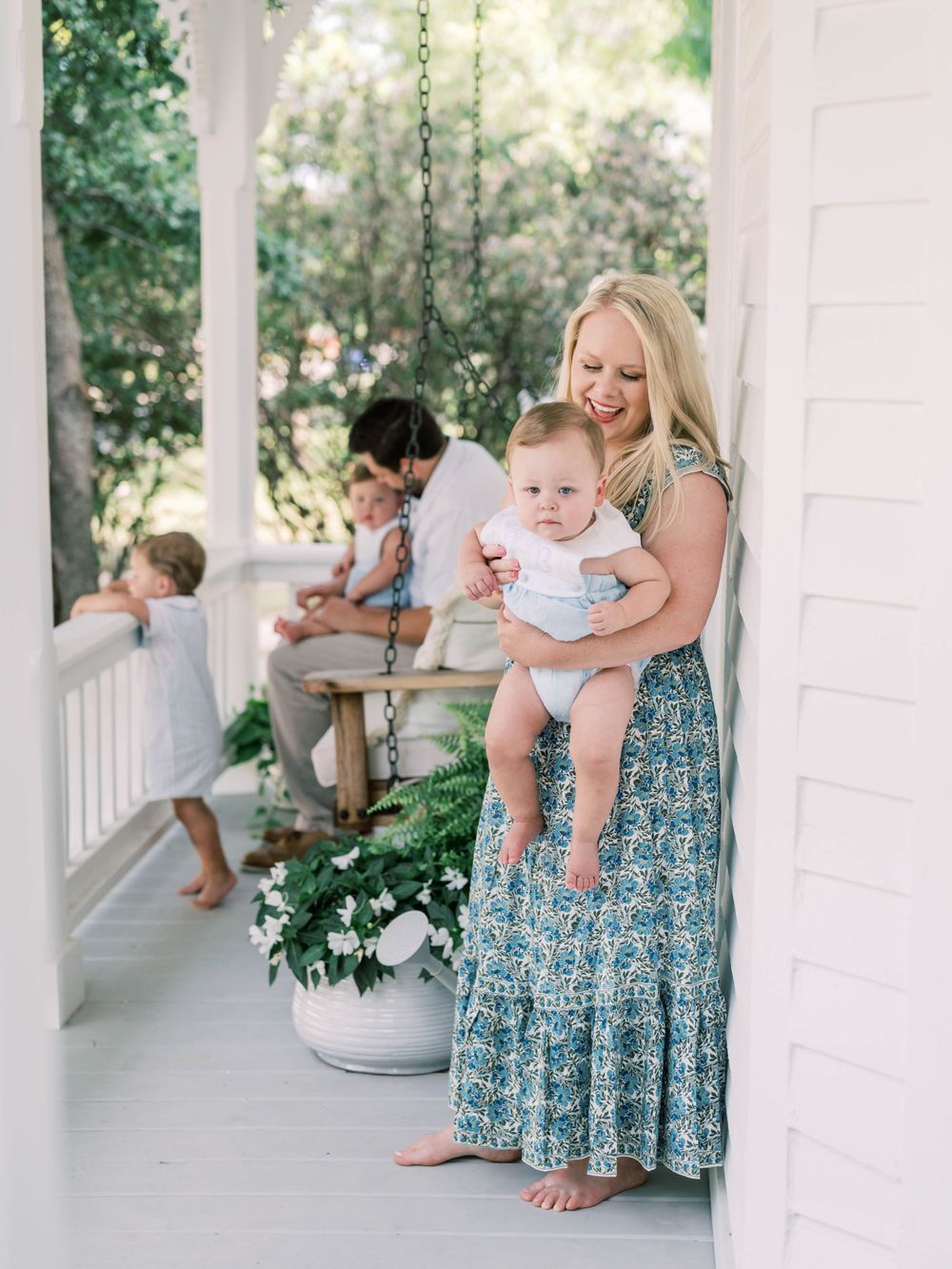 studio newborn session on a front porch of mom holding a baby boy