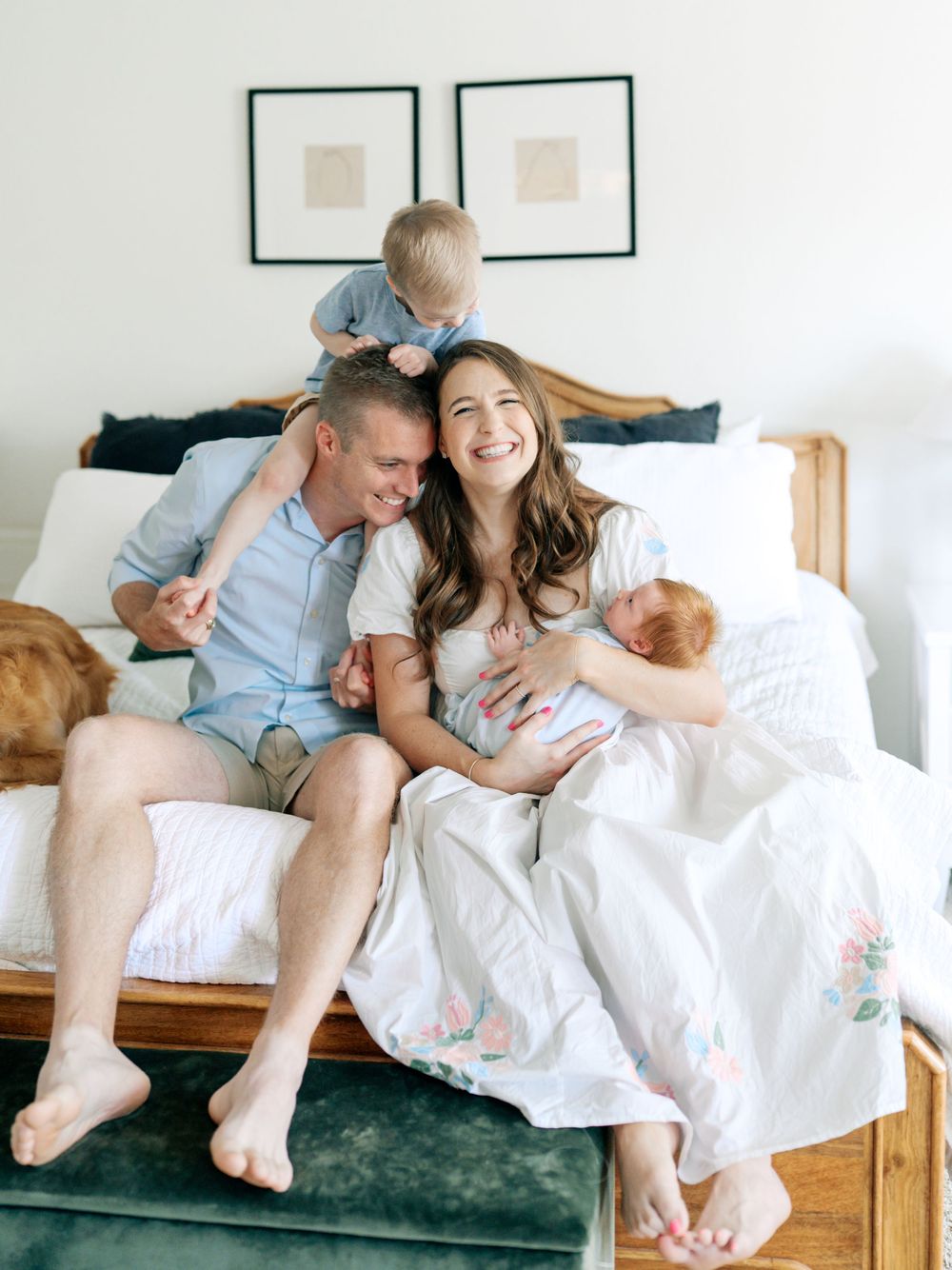 A couple relaxes and cuddles together on a white couch in a bright, minimalist room.