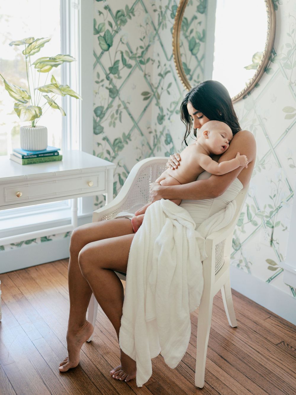 A series of artistic photographs showing a figure in white fabric seated on a wooden chair against floral wallpaper.