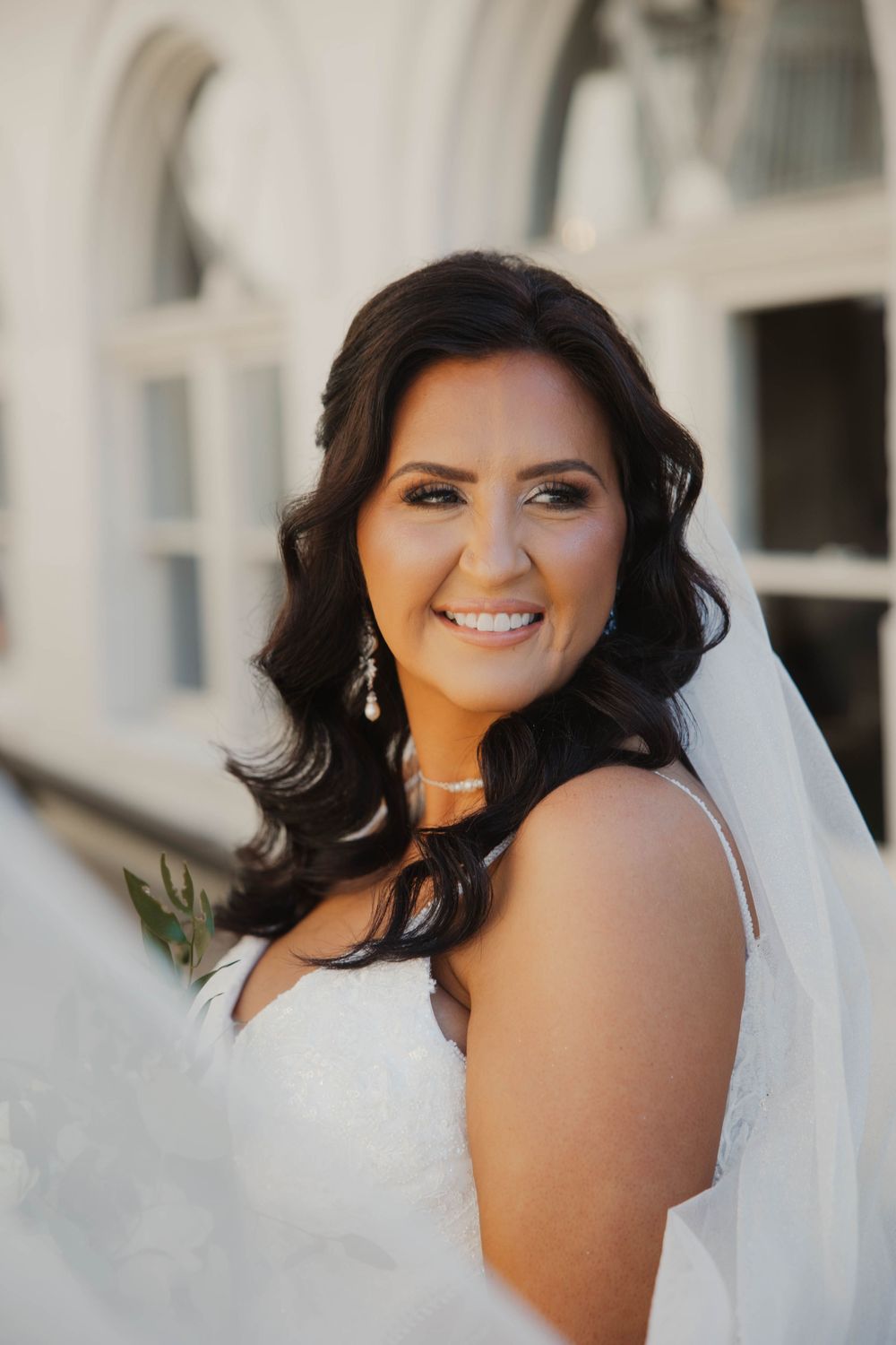 Close-up bridal portrait with soft lighting and a flowing white veil.