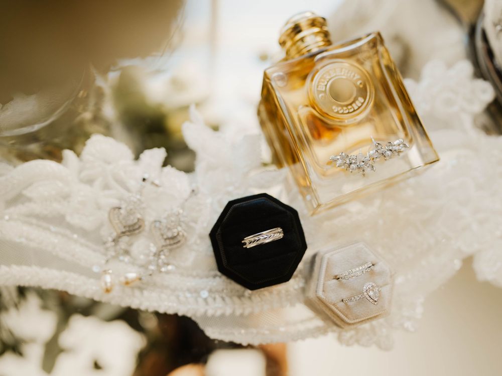 Wedding perfume bottles and accessories arranged on white lace in elegant detail.