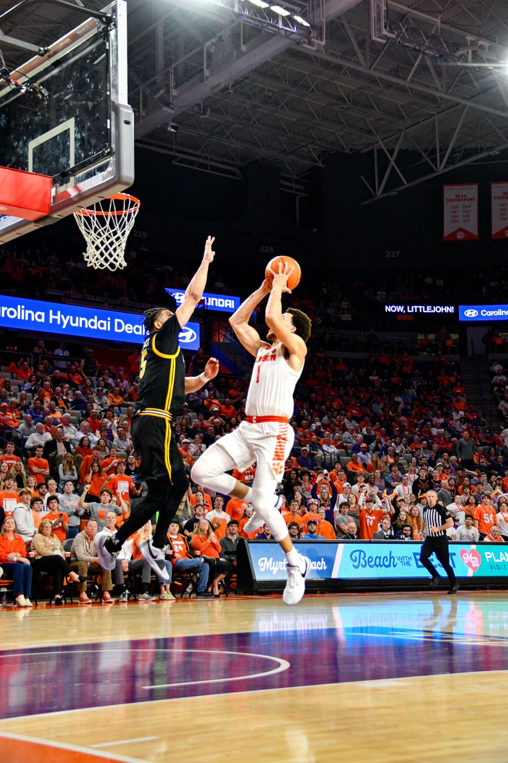 Basketball player taking a jump shot during intense game action at Clemson.