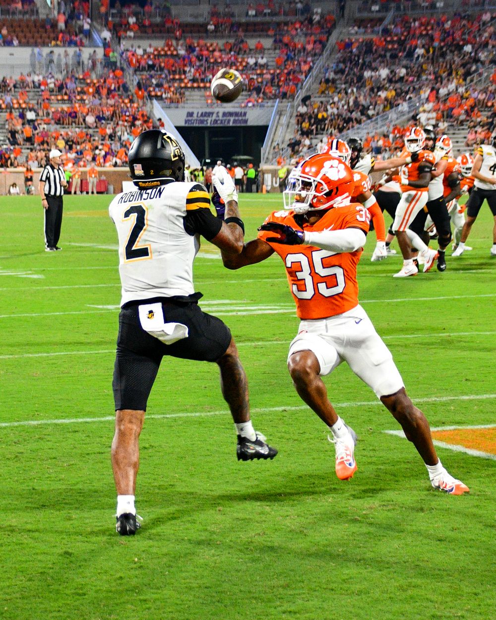 Football players from opposing teams compete for the ball during intense game action.