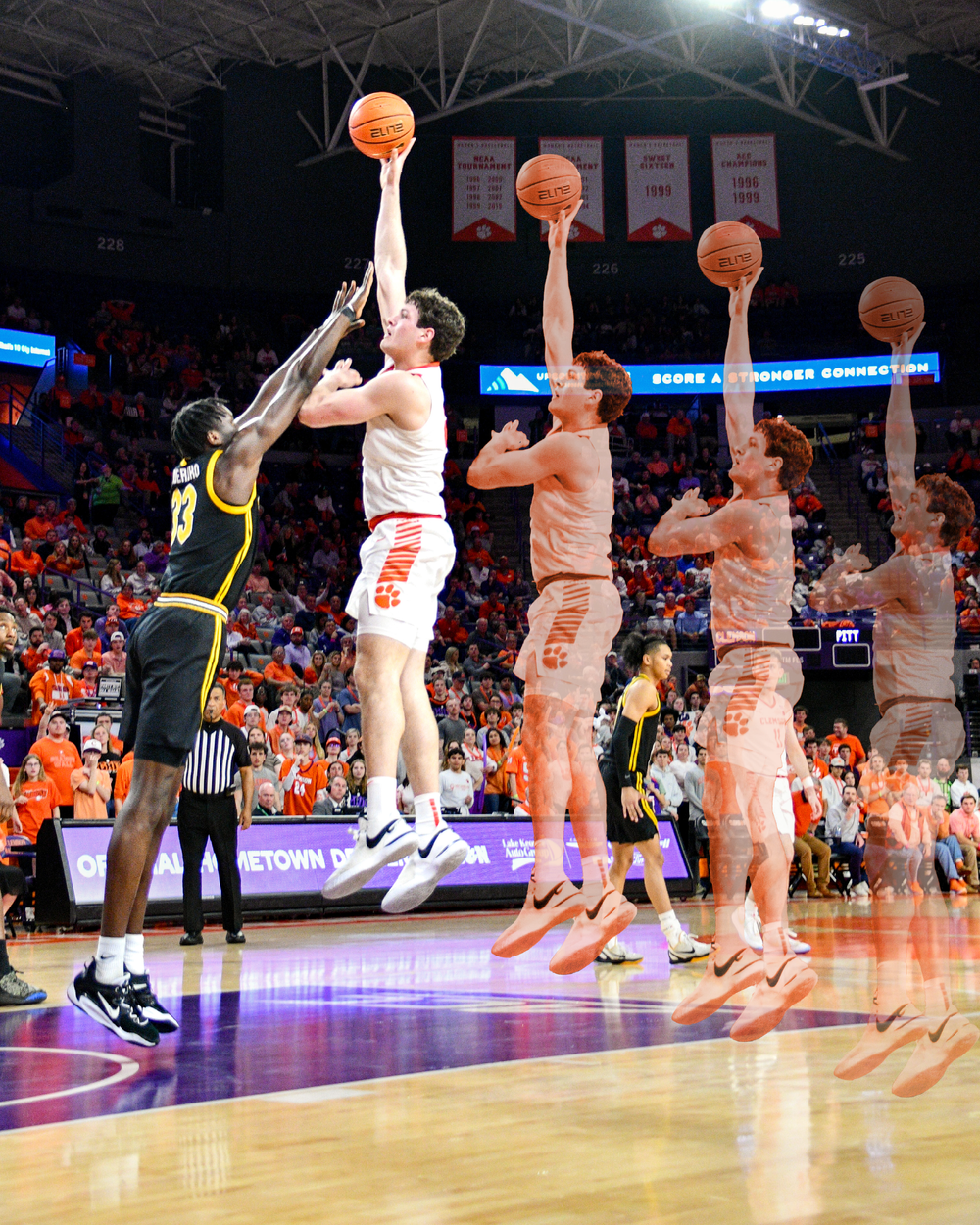 Basketball players lined up practicing shots during a game at Clemson's arena.