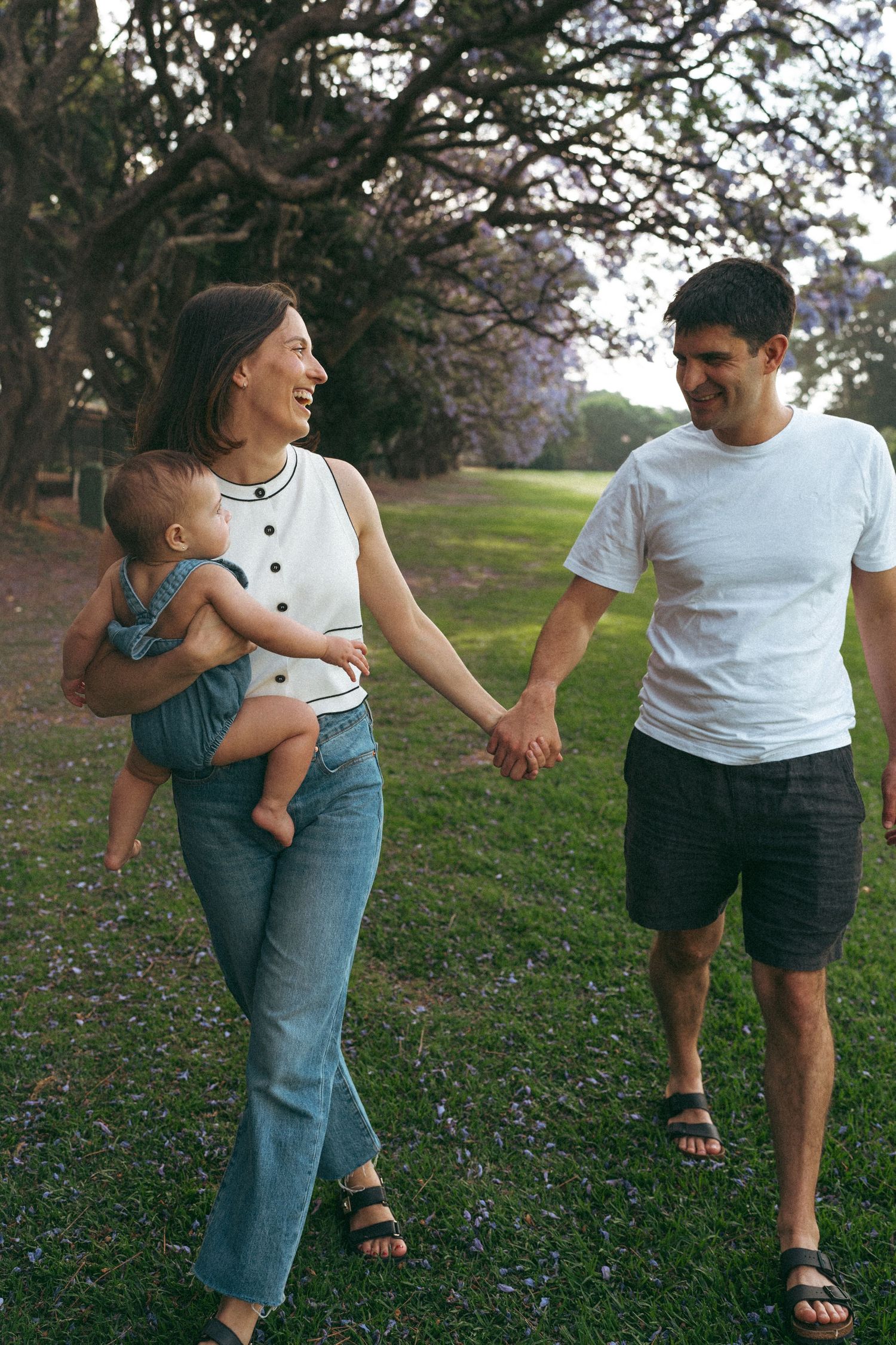 Sequence showing family members walking together on grass under trees in natural lighting.
