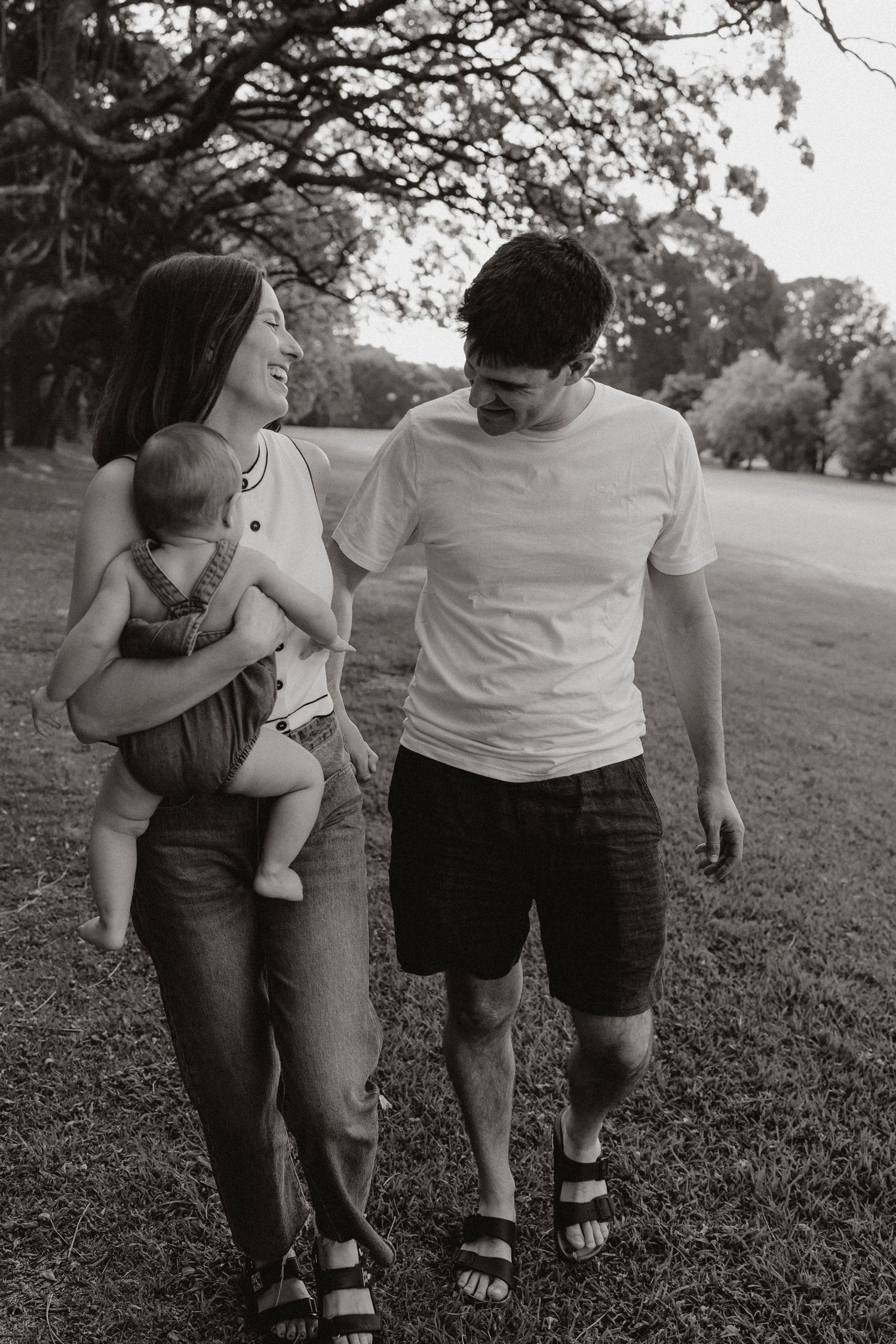 Black and white series of family walking together through parkland.