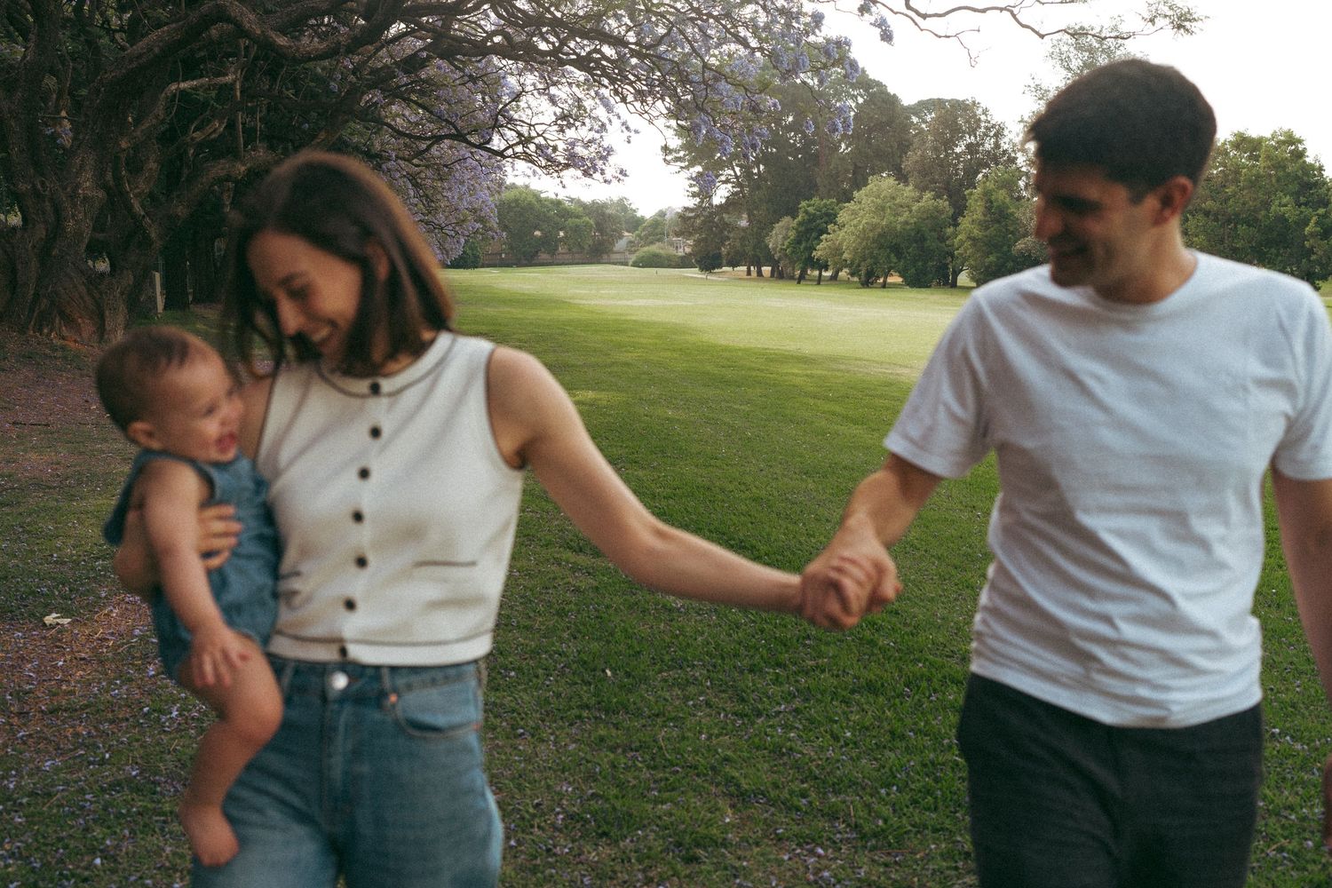 Family members walking together outdoors in casual summer attire.