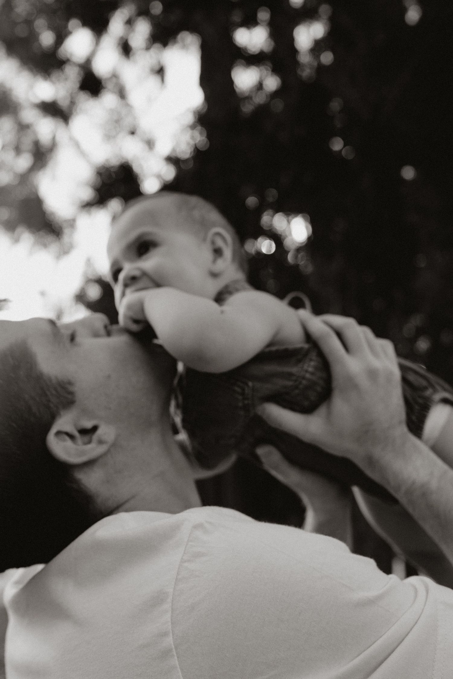 A tender black and white photo sequence showing playful interaction between parent and baby.