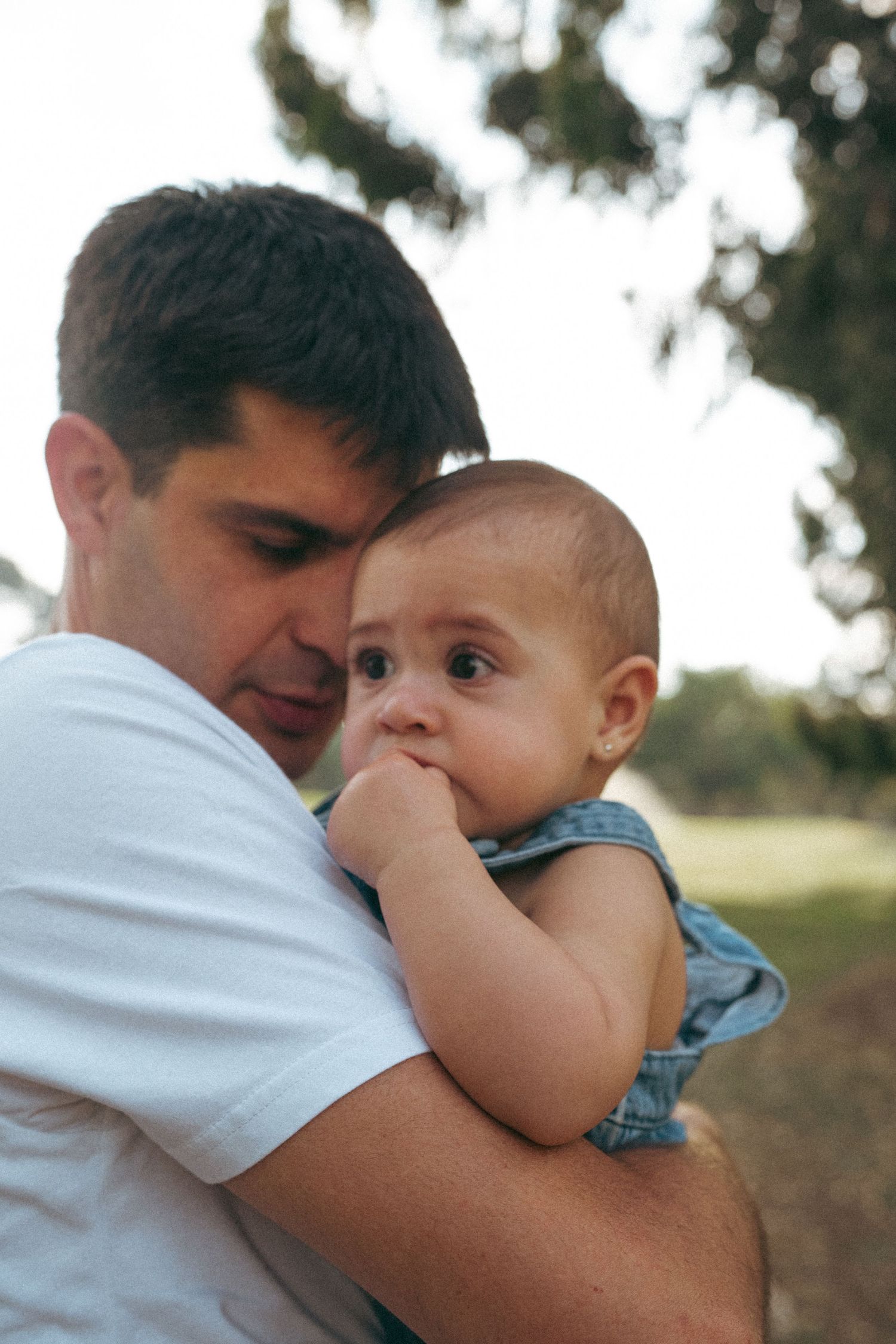 Sweet candid moments captured between parent and infant in natural lighting.
