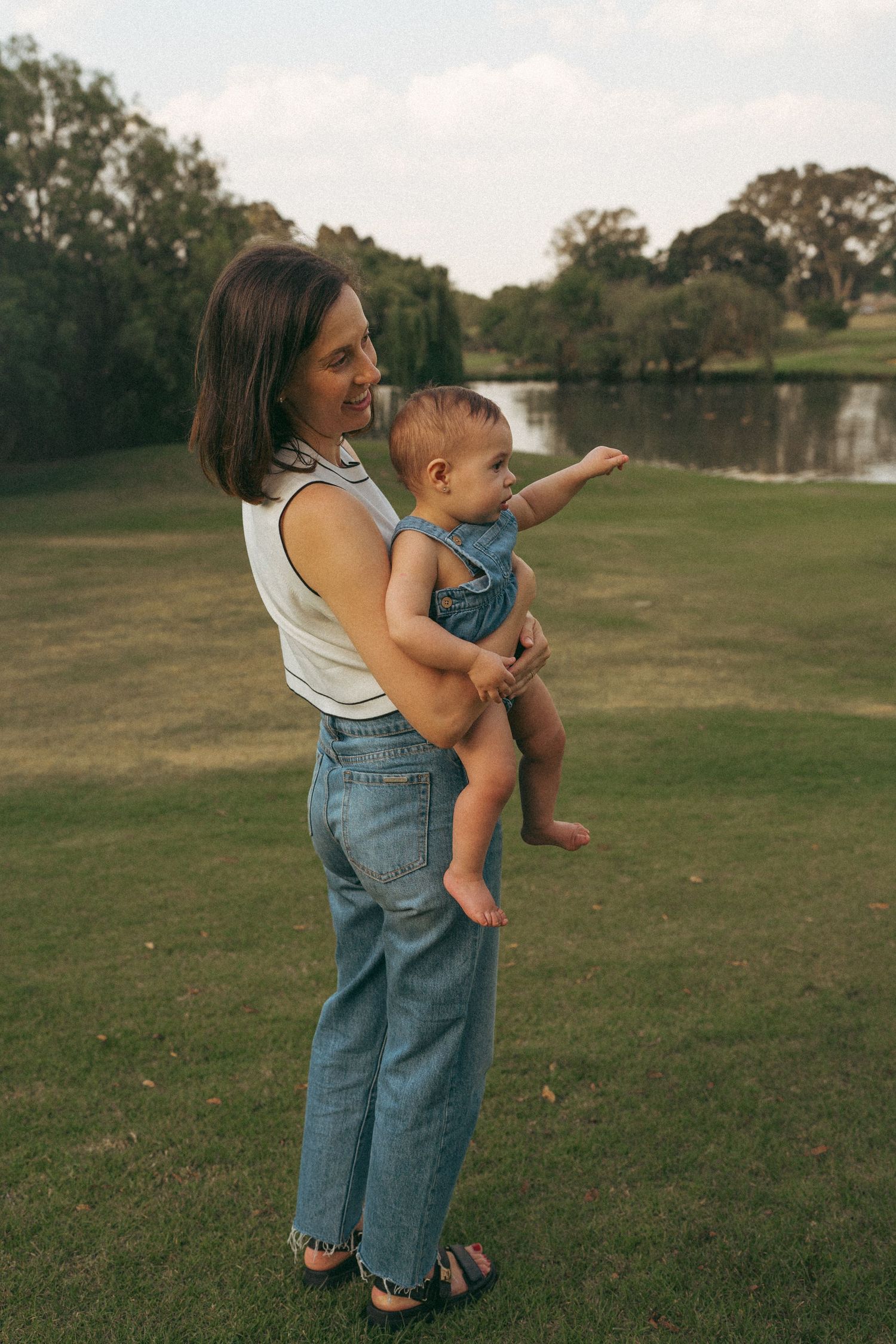 Parent and child share a moment together in an open field at dusk.