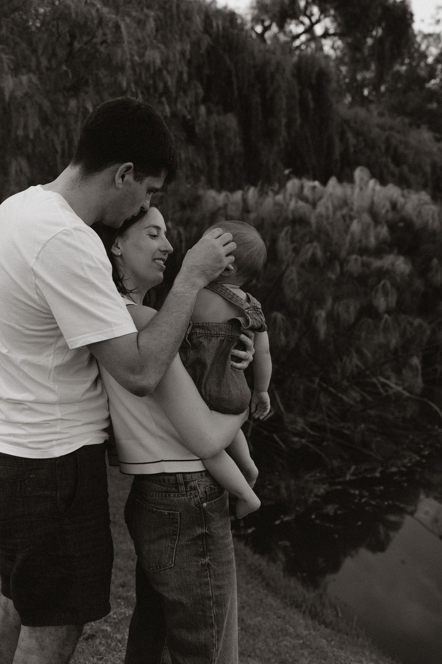 Emotional black and white portrait showing tender family embrace outdoors.
