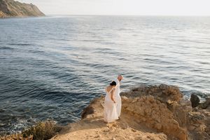 a newly engaged couple walking down a cliff