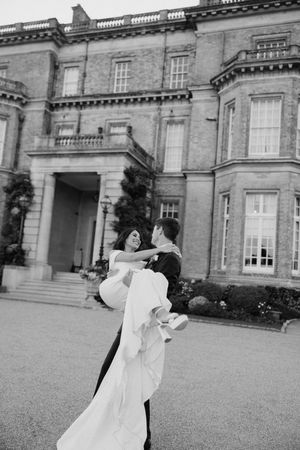 newly weds having a candid moment in front of hedsor house
