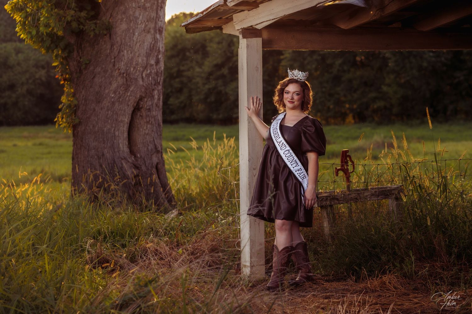 Cumberland County beauty pageant Queen leans against a barn pole on the Cumberland County fairgrounds after fair week Amber Helm Photography