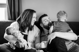 Black and white family portrait showing joyful moments on couch.