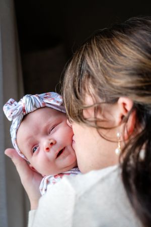 A sweet moment captured between parent and baby with matching floral bow headband.