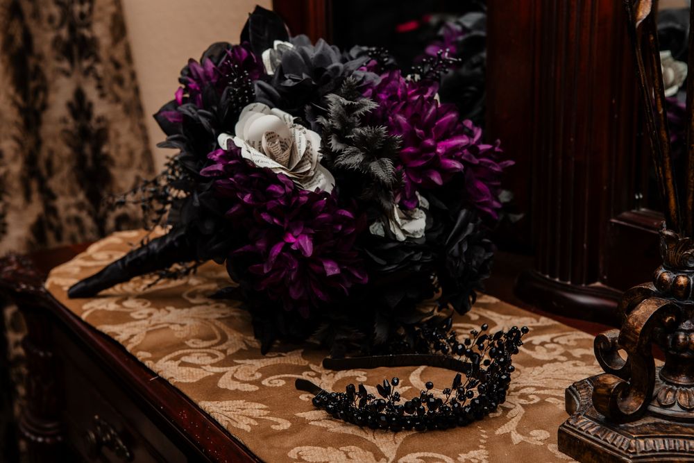 Dark and moody still life of gothic-style floral arrangements with purple flowers.