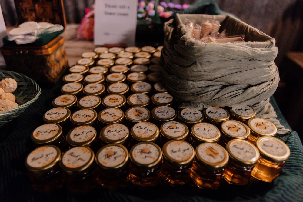 Rows of small glass jars arranged on a dark surface at a wedding reception or event.