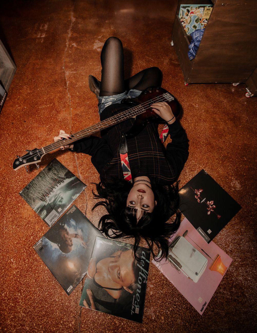Artistic senior overhead shot of vinyl records scattered on orange carpet.