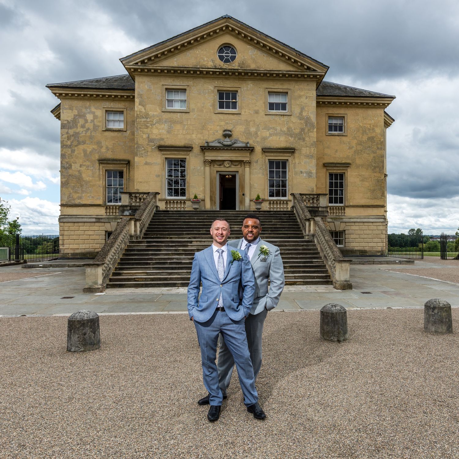 Two grooms posing for formal photographs outisde their wedding venue, Danson House in Bexley, Kent