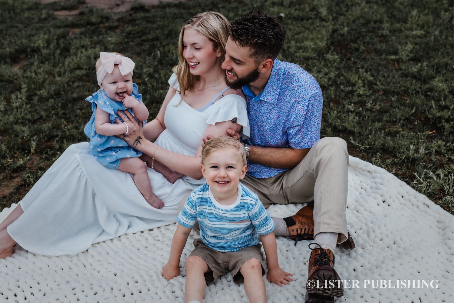 Family enjoying playful outdoor moments together on grassy field at sunset.