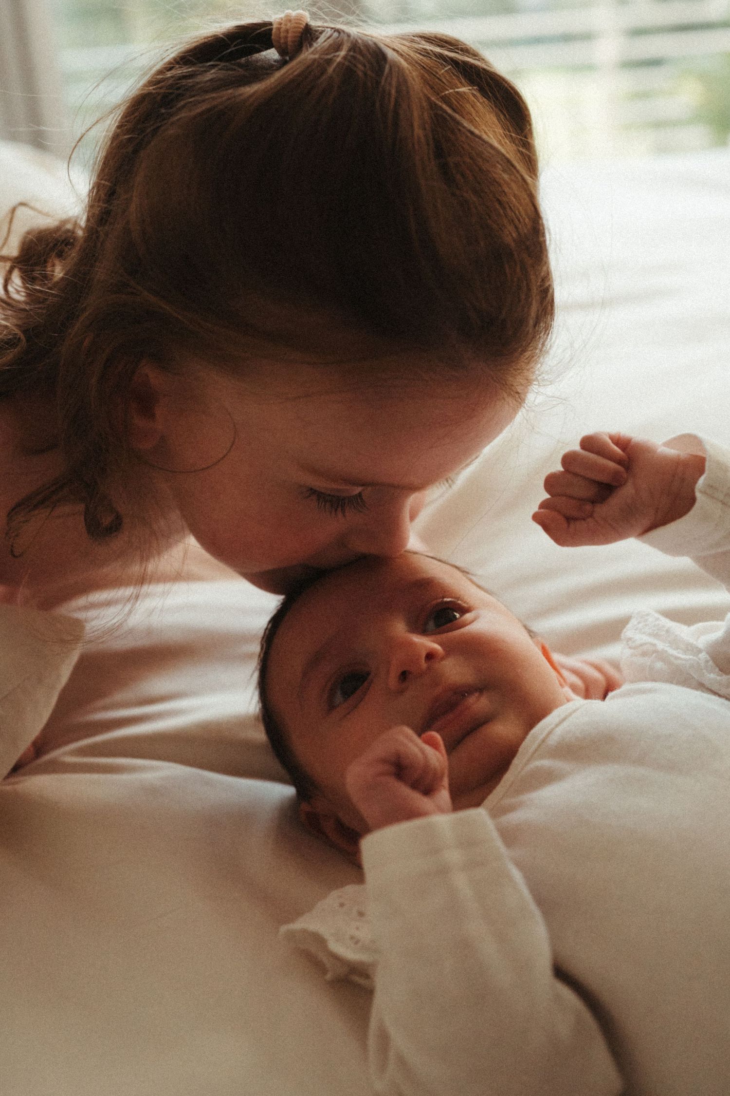 Sweet morning interaction between parent and child in soft natural light.
