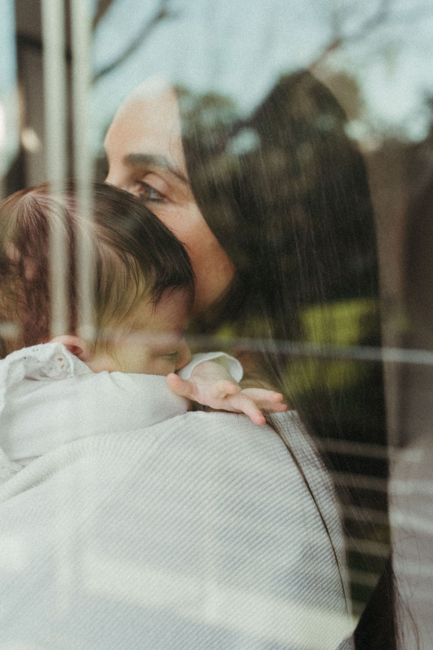 Reflective window portraits capturing intimate family moments with natural backlighting.