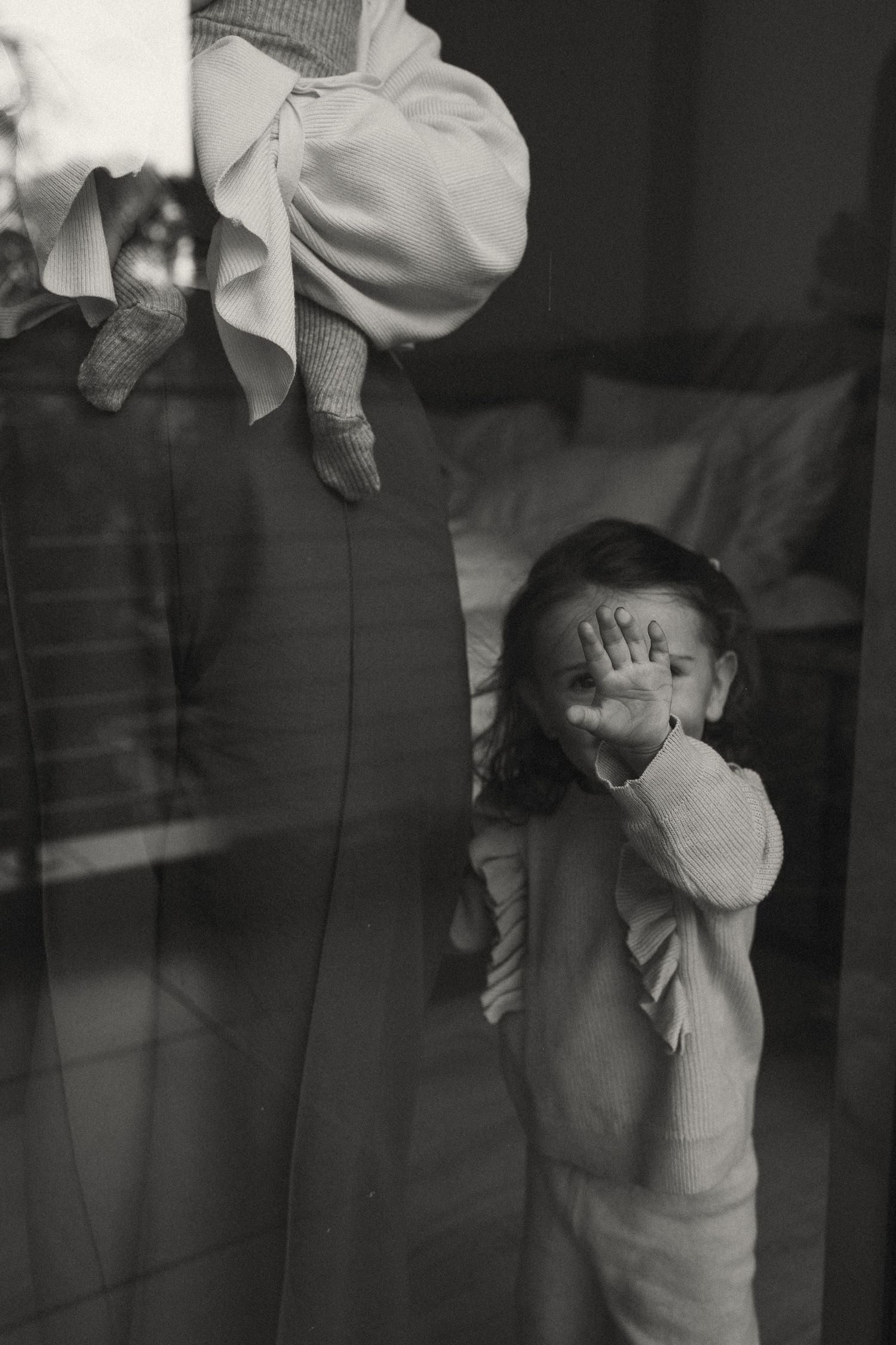 Moody black and white series capturing tender embraces through glass.