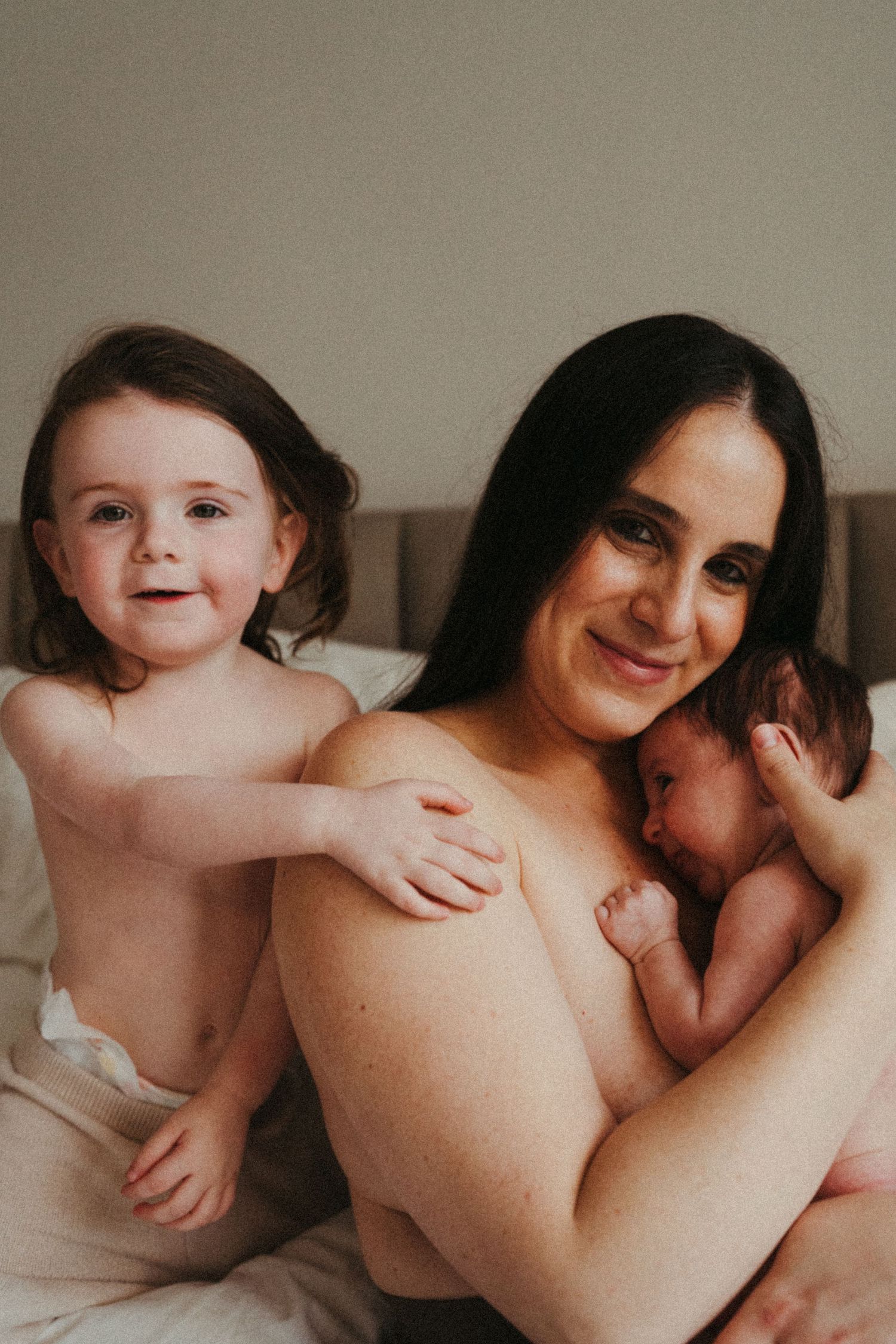 Joyful intimate portrait of parent with two children sharing loving embrace.