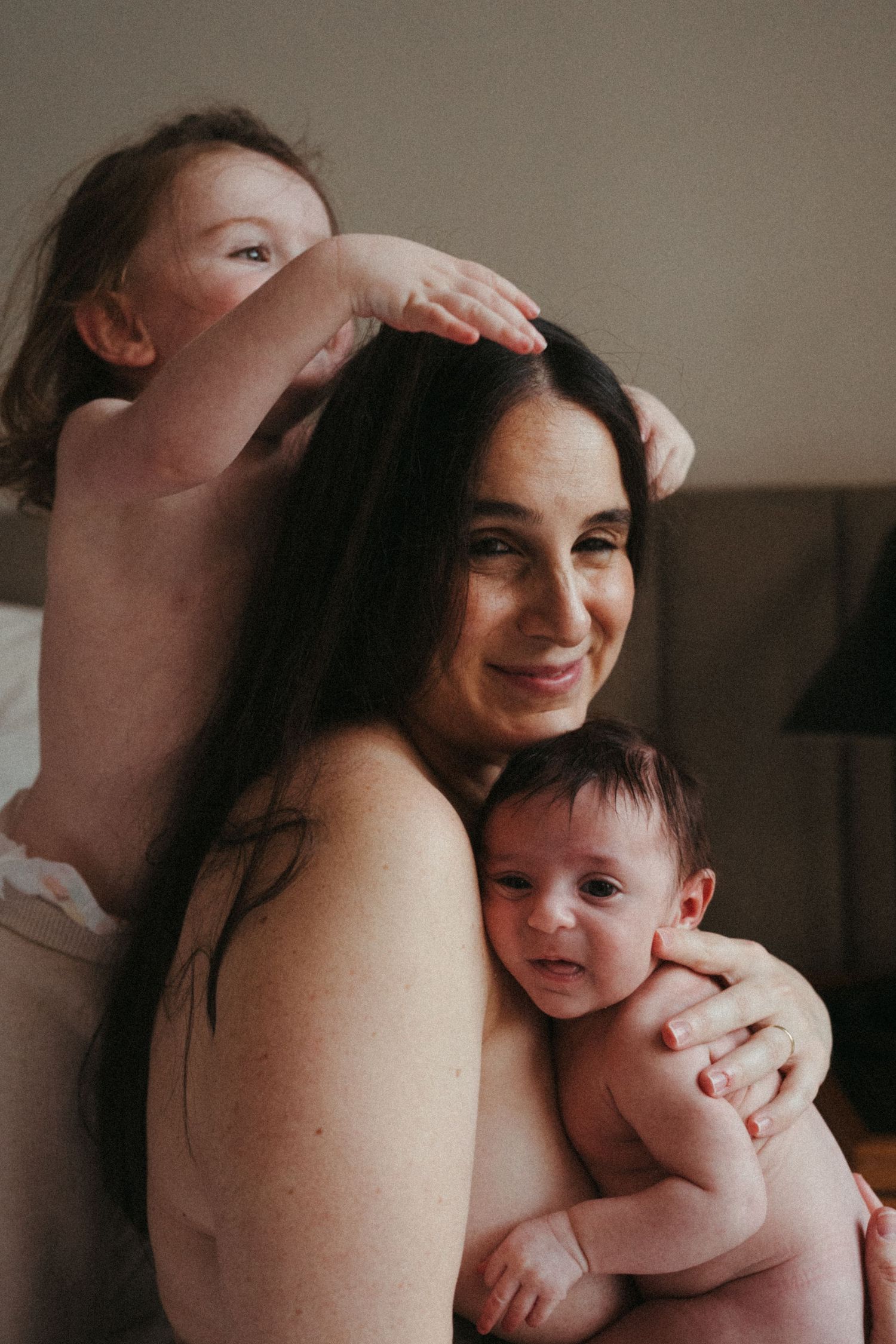 Candid portrait showing playful family moment with parent and two children.