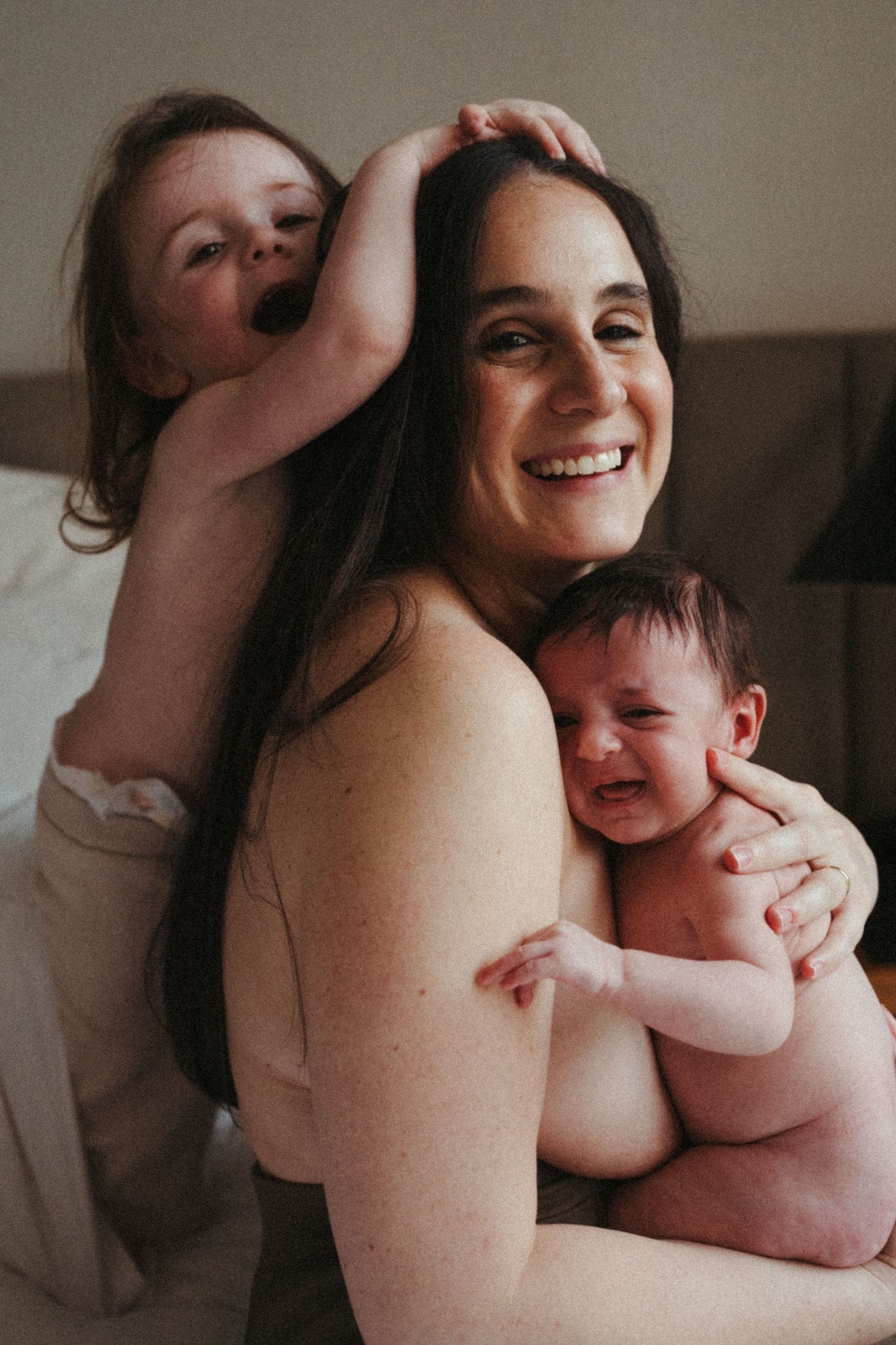 Natural light portrait showing happy family moment with parent and children.