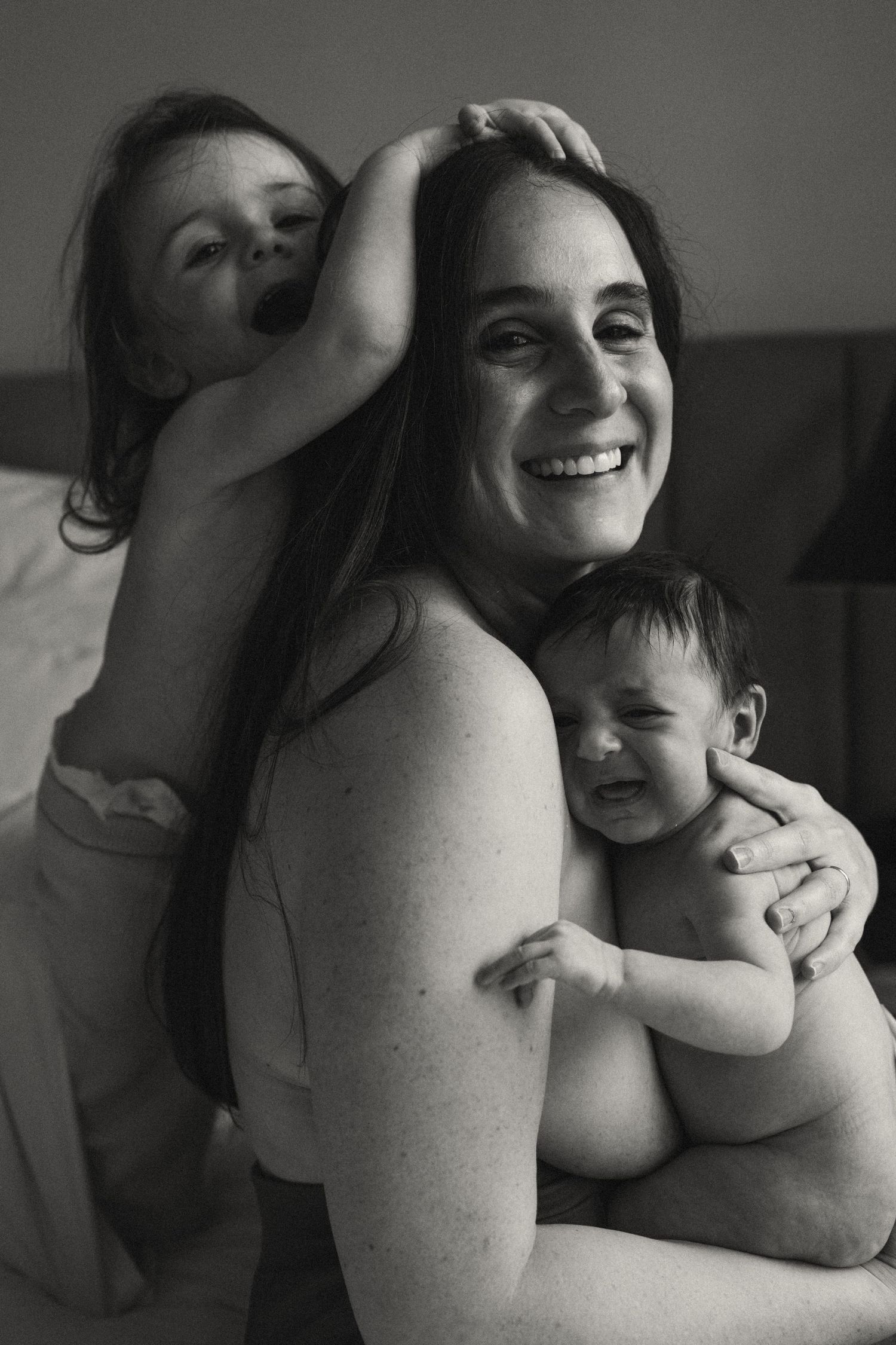 Black and white portrait capturing joyful family embrace.