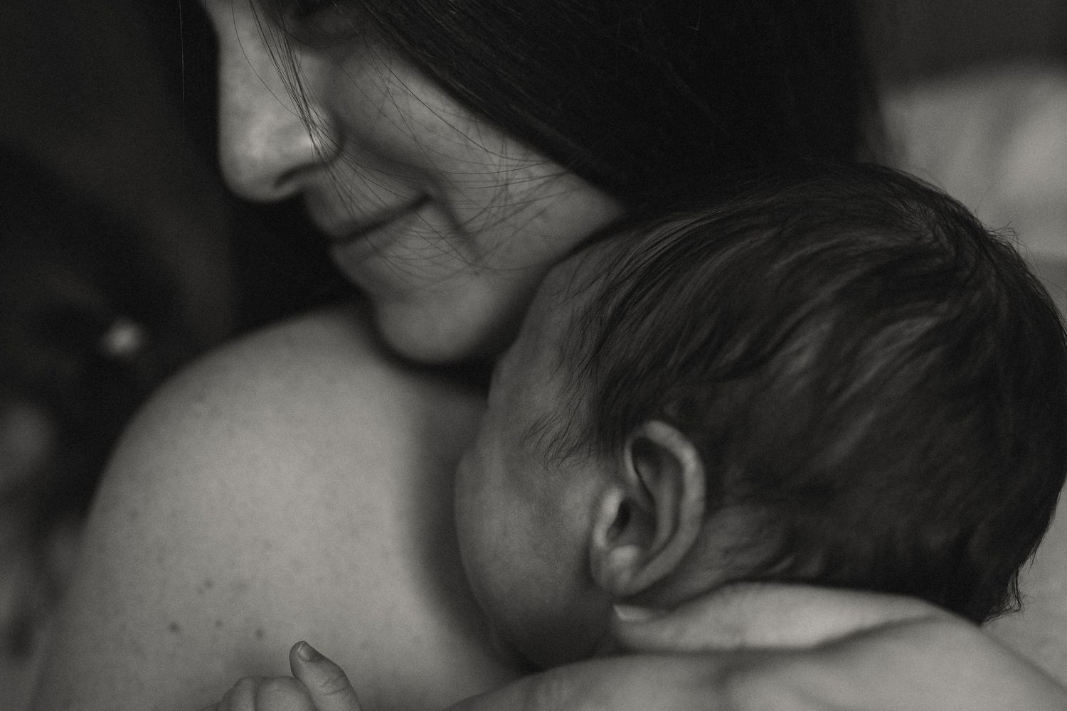 Close-up black and white portrait showing intimate emotional expressions in soft lighting.