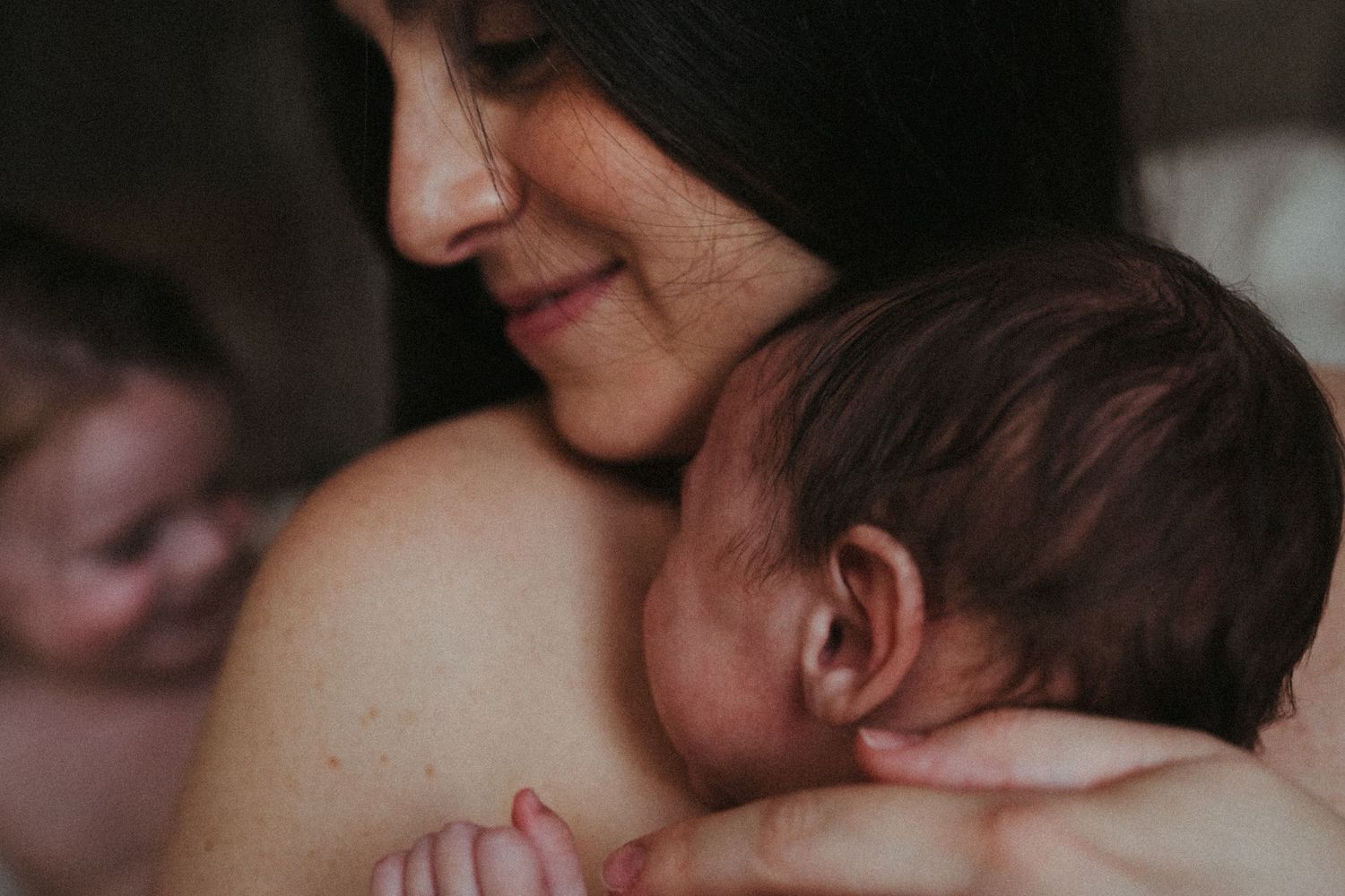 Tender intimate moment captured in moody black and white lighting.