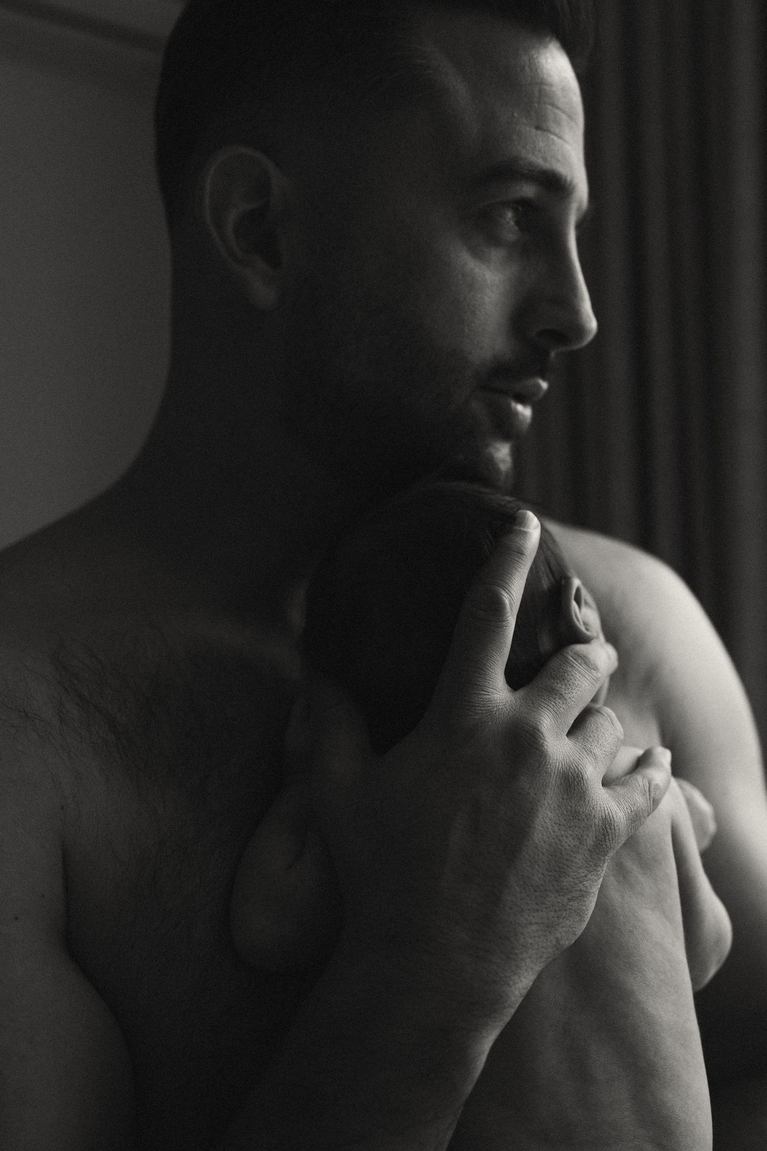 Dramatic side profile portraits in moody black and white lighting.