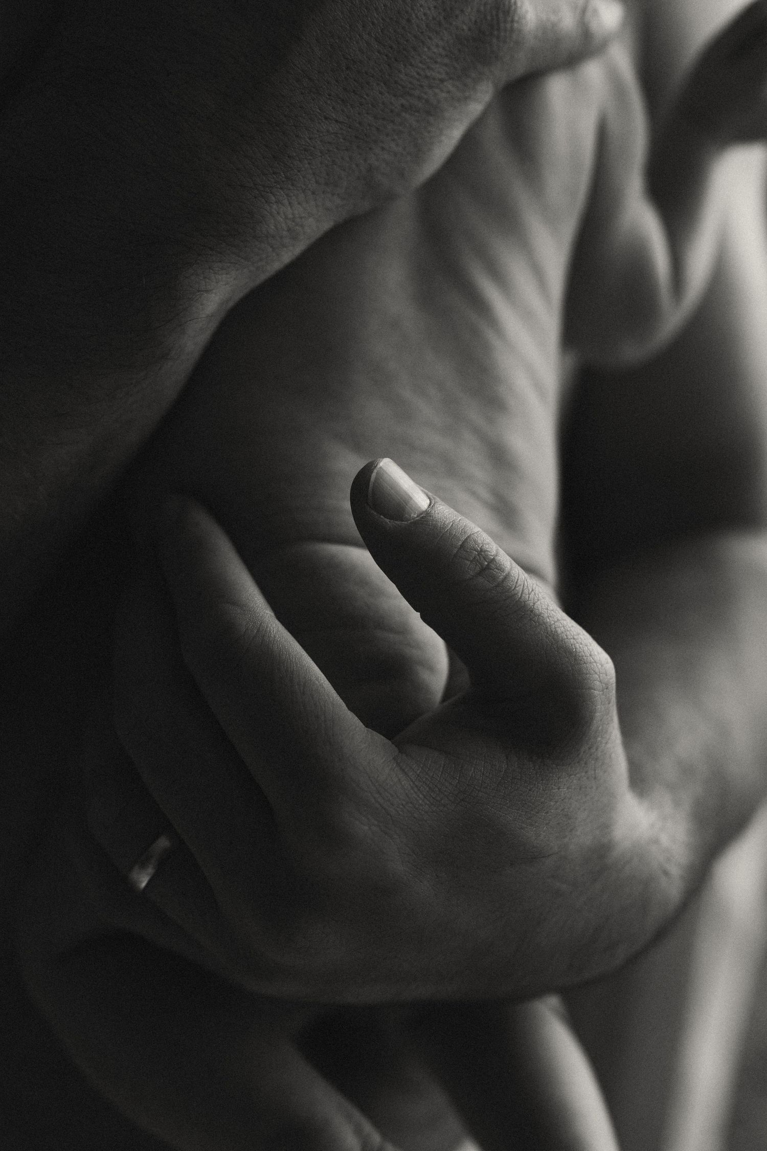 Abstract black and white close-ups of hands and skin in shadow.