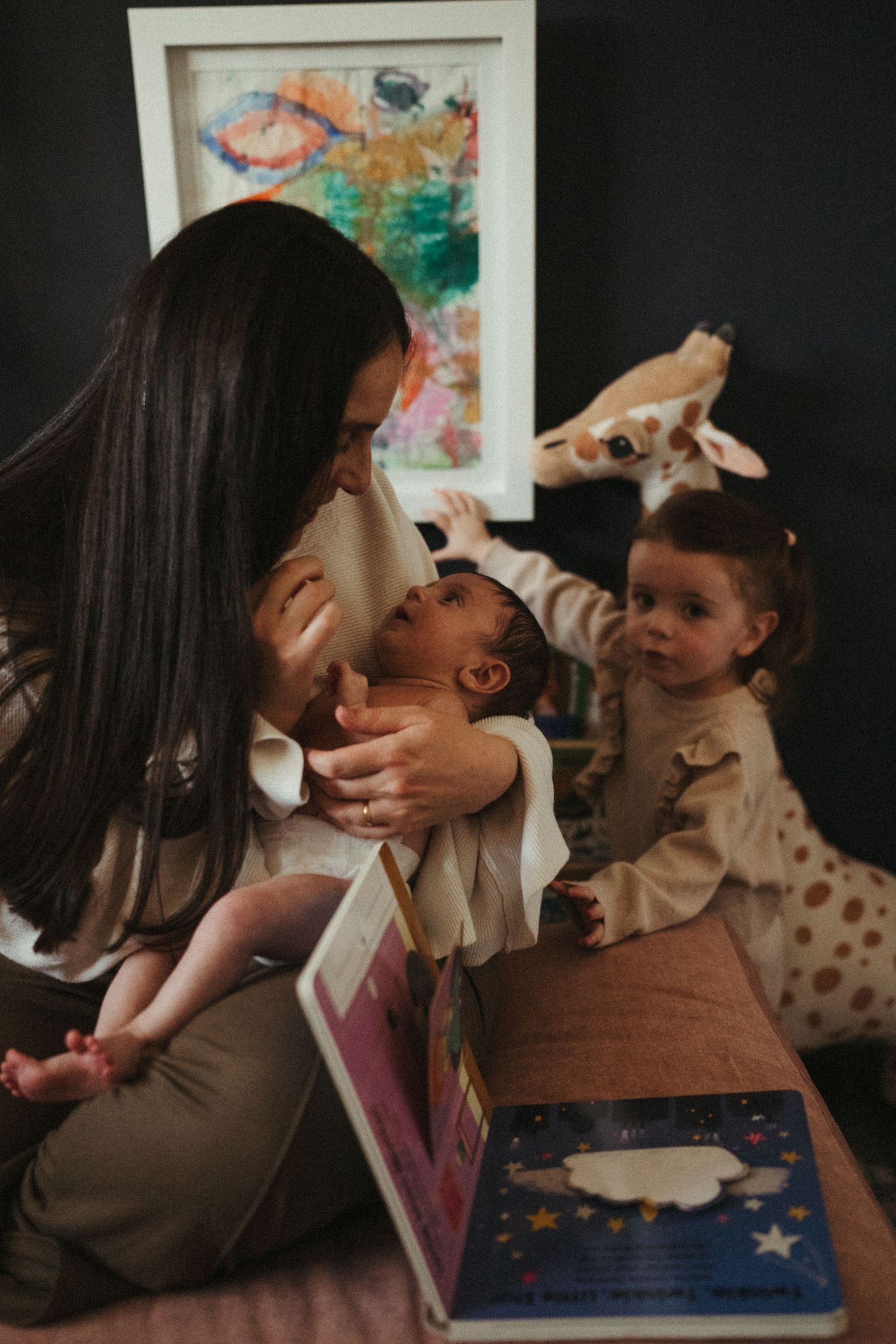 Intimate family moments captured in warm lighting with a tablet device nearby.