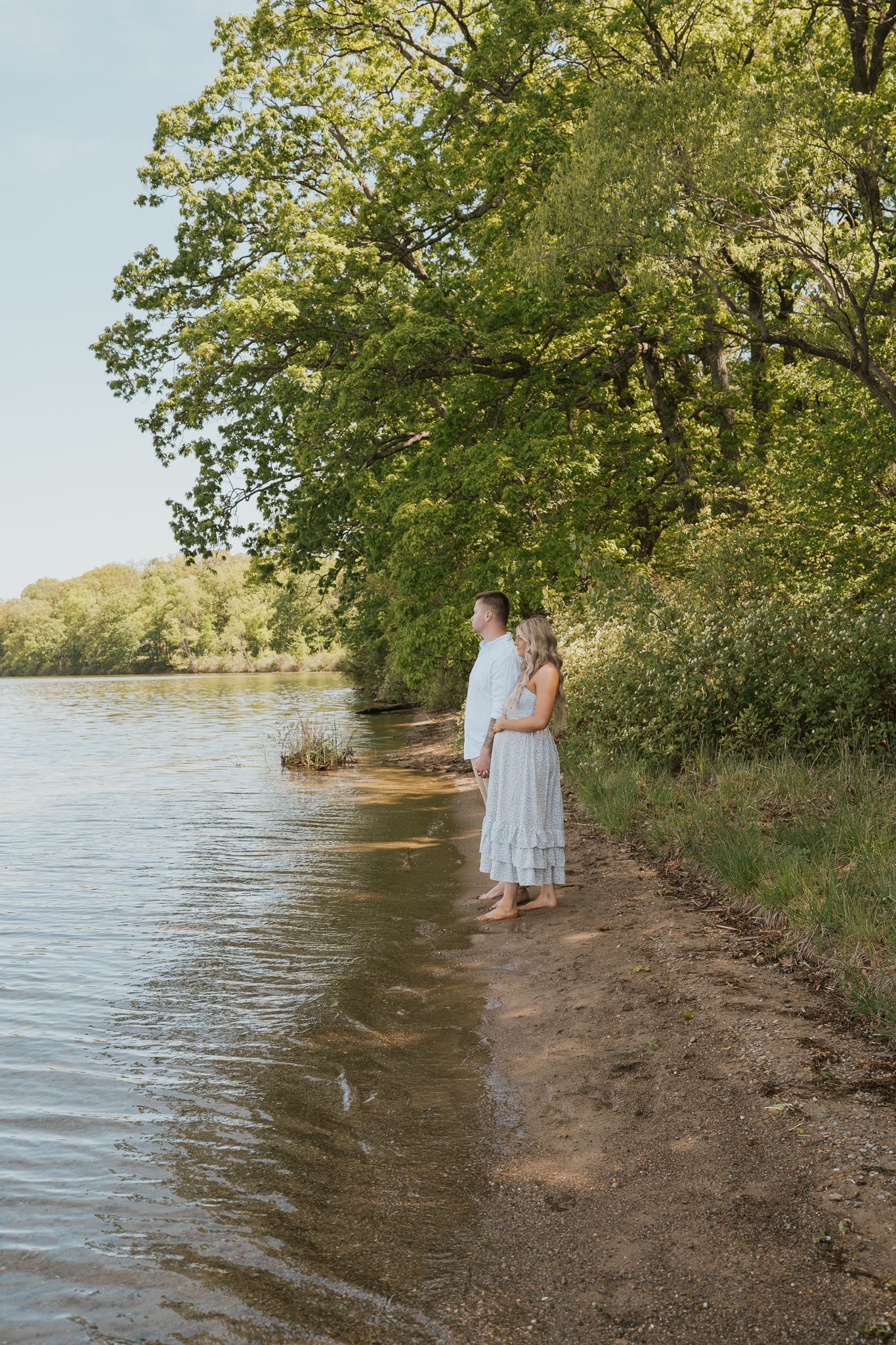 Scenic waterfront maternity photos with trees and shoreline in Angola Indiana.