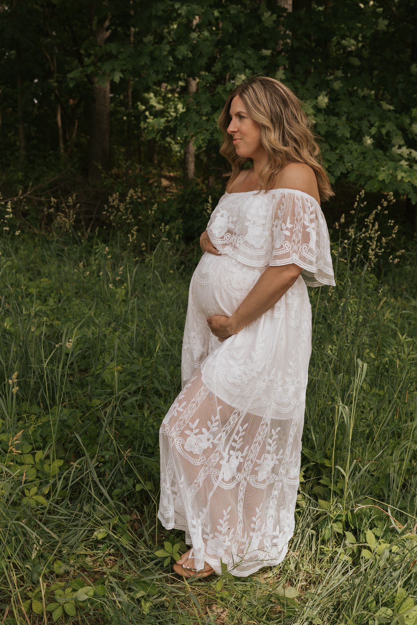 Ethereal maternity photos featuring white lace dress in wooded setting in southern Michigan.