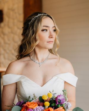 Bridal portrait showcasing soft waves, delicate headpiece and statement necklace.