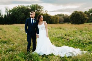 A couple shares romantic moments in a sunlit meadow during their wedding photoshoot.