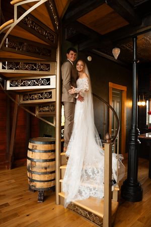 A sequence of wedding photos showing a bride and groom near rustic wooden barrels in a warmly lit indoor venue.