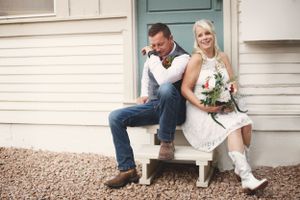 Rustic engagement photos on a farmhouse porch with vintage white wooden details.