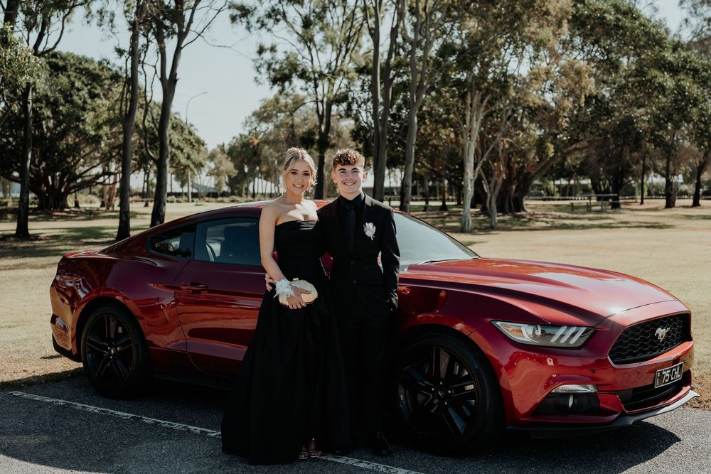 A red sports car photographed in an outdoor setting with trees at gladstone.
