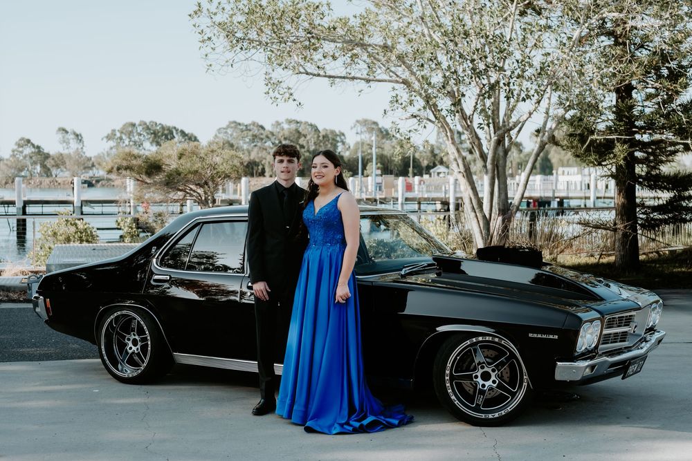 A classic black vintage car parked outdoors with elegant styling details.