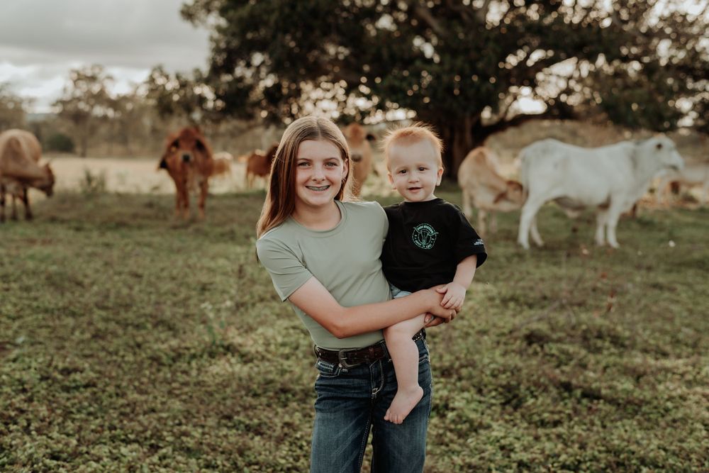 Family members enjoy candid moments together in rural gladstone pasture with horses.