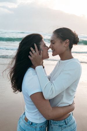 romantic couple embracing during sunset with cinematic lighting and ocean backdrop